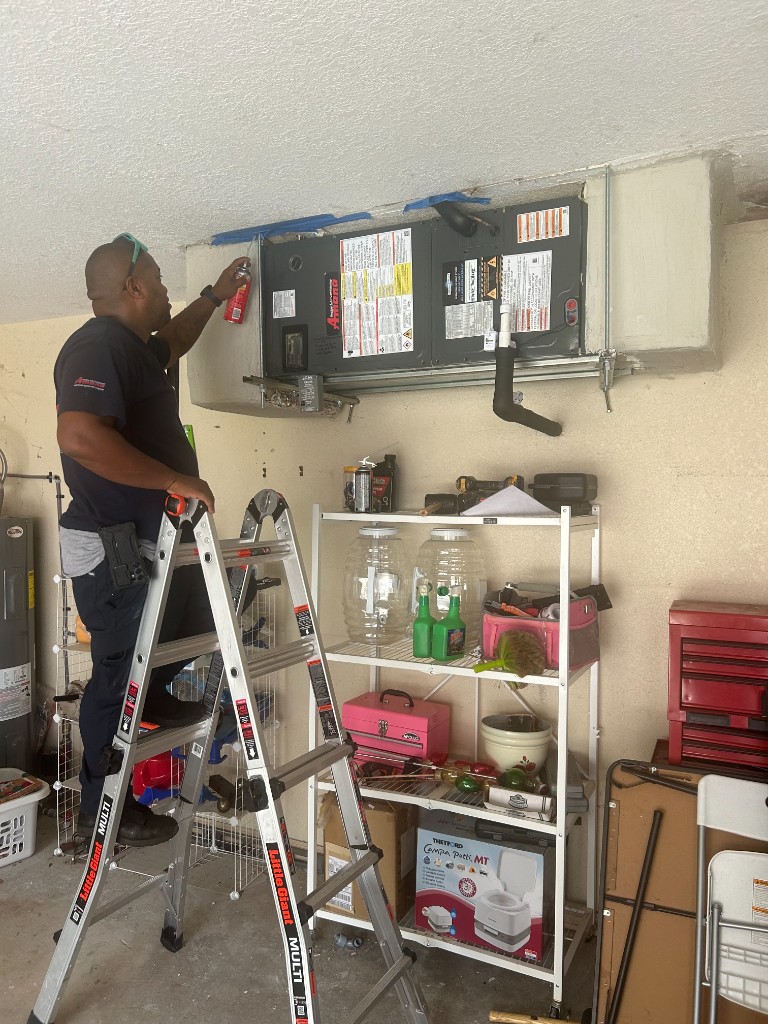 Integrity technician on ladder servicing an indoor HVAC unit